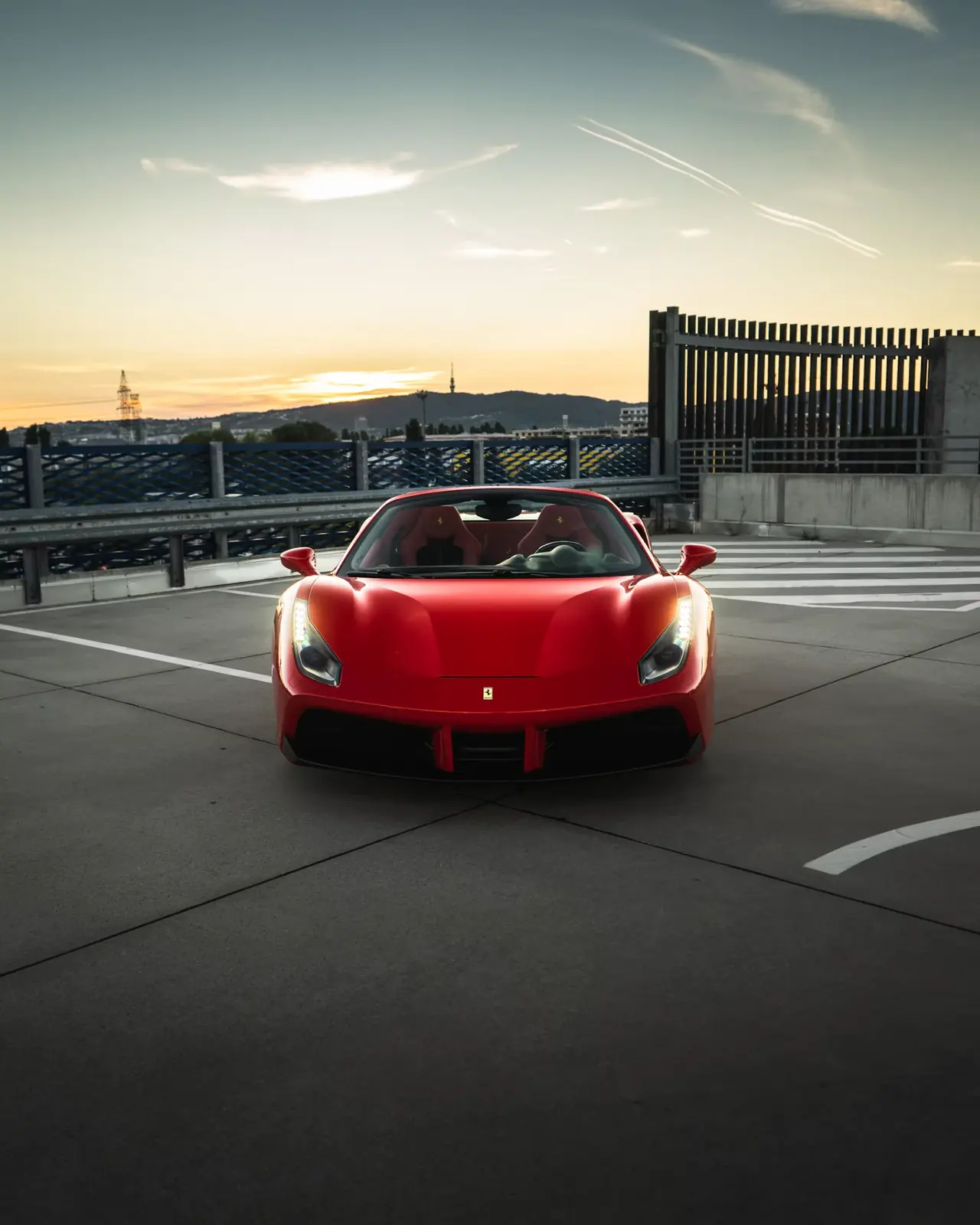 Gün batımında çatı otoparkında kırmızı Ferrari